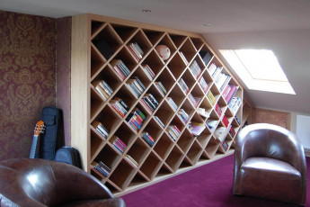 Attic library with diamond shaped shelves in oak